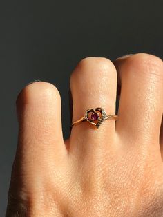 Please no orders to the USA for under $100 CAD due to Canada post strike! No orders outside Canada or the US at this time. Vintage 10k gold ring with a heart design. Has a small ruby centre and one small diamond on the side. Stamped and tested 10k gold. In great condition with minor signs of wear.   Fits US ring size 6  7mm long at the heart 1.5mm wide at the base of the ring 1.27 grams in weight Will be mailed with tracking and in a gift box! Classic Heart-shaped Ruby Ring, Heart-shaped Ruby Ring Gift, Heart-shaped Yellow Gold Ruby Ring, Heart-shaped Ruby Ring With Diamonds As A Gift, Heart-shaped Ruby Ring With Center Stone As Gift, Ruby Heart, 10k Gold Ring, Diamond Heart Ring, Solid Gold Rings