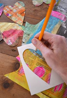 someone is cutting out paper hearts with a pencil