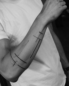 a man's arm with a cross tattoo on it, in black and white