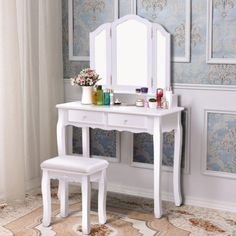 a white dressing table with a mirror and stool