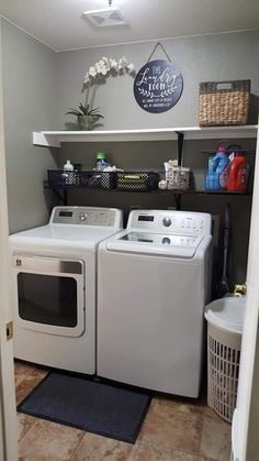 a washer and dryer in a laundry room with shelves on the wall above them