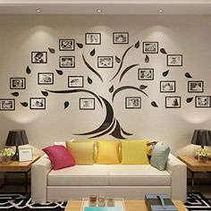 a living room with pictures on the wall and a tree painted on the wall behind it