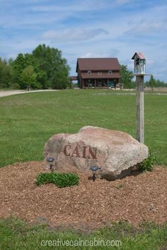 a large rock sitting in the middle of a field with a mailbox on it