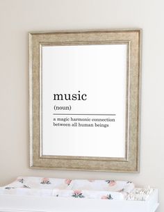 a framed poster on the wall above a baby crib with music definition in it