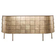 a gold colored sideboard with square tiles on the front and legs, against a white background