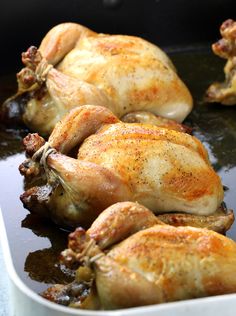 several whole chickens are cooking in a pan