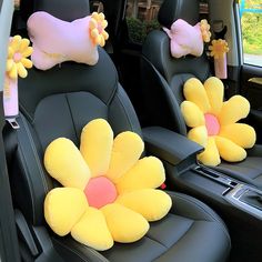 two yellow flowers are sitting in the back seat of a car with pink bows on them