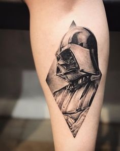 a black and white photo of a star wars tattoo on the right thigh with a darth vader helmet