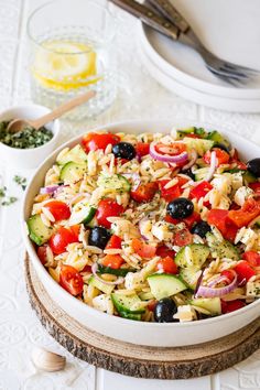 a white bowl filled with pasta salad and olives