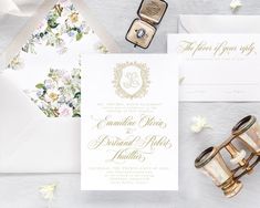 the wedding stationery is laid out on top of each other, including an envelope and ring