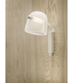 a white wall light mounted on the side of a wooden wall