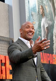 a man in a suit waves to the crowd