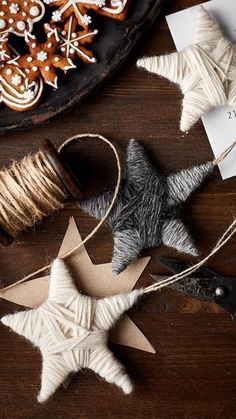 various christmas decorations are laid out on a table with twine, scissors and other crafting supplies