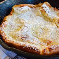 a skillet with some powdered sugar on top of it next to a napkin