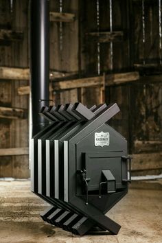 a black and white object sitting on top of a wooden floor next to a pole