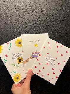 hand holding three birthday cards with sunflowers on them