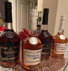 three bottles of henness fine whine on a counter