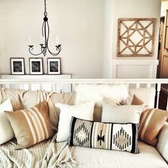 a white couch with pillows and pictures on the wall