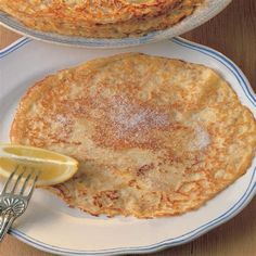 two pancakes on plates with a fork and knife