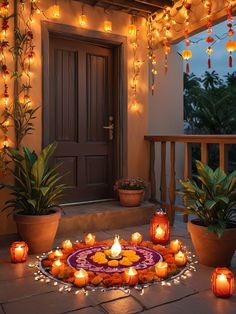 an outdoor area with candles and potted plants on the ground next to a door