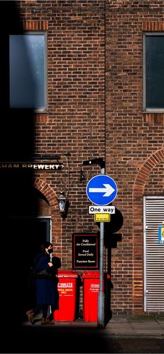 a blue and white street sign next to a brick building