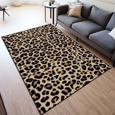 a living room area with a couch, chair and leopard print rug on the floor