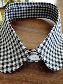 a black and white checkered bow tie sitting on top of a wooden table