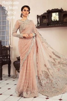 Our contemporary saree rendered in hue of powder pink with a beaded neckline and pearls, diamonties, sequences along 3D floral accents with intricate cutwork detailing and a scalloped worked velvet border. COLOR: Saree: Powder Pink Petti Coat: Powder Pink Replicate Designs by team Fancy Aura