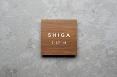 a wooden plaque with the name shinga on it sitting on top of a wall