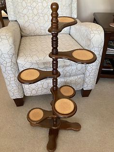 three tiered wooden display stand in the middle of a living room with a chair behind it