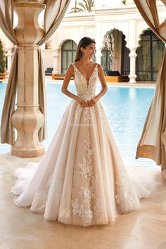 a woman standing in front of a pool wearing a wedding dress