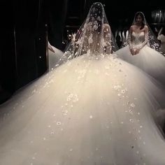 two women in wedding gowns standing next to each other