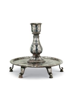 an ornate silver plate with two candle holders on the top and one is sitting on a stand