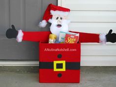 a santa claus costume is sitting in a cardboard box with his arms out and feet up