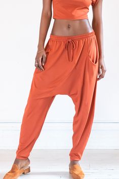 drop crotch knit pant with elastic waist, and asymmetrical seamwork Drop Crotch Pants Women, Harem Joggers, Sarouel Pants, Outfit Minimal, Silky Pants, Sheer Pants, Drape Pants, Drop Crotch Pants, Orange Outfit