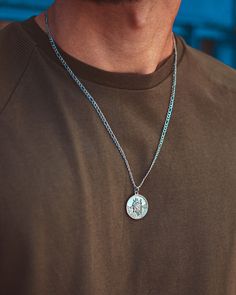 Silver St Christopher Pendant necklace. This striking piece is going to take centre stage on your outfit. Be bold and rock this on its own or with a combination of silver accessories- just take a look on our necklace page. Model is wearing a 22" Figaro chain on this necklace - this is sent as standard unless another chain style or length is selected in the personalisation section. Made from Premium quality 316L stainless steel with a Polished Silver stainless steel finish. Guaranteed to never fa Silver Figaro Chain Jewelry With Round Pendant, Silver Jewelry With Figaro Chain And Round Pendant, Silver Figaro Chain Pendant Necklace, Silver Figaro Chain Medallion Jewelry, Silver Pendant Necklace With Figaro Chain, Silver Medallion Figaro Chain Jewelry, Silver Medallion With Figaro Chain, St Christopher Necklace, St Christopher Pendant