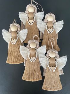 four wooden angel ornaments with hearts and tassels