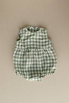 Product photos - green gingham. The model is wearing a romper in yellow gingham. All-day comfort is guaranteed with this sleeveless romper crafted from gingham linen. The fabric is soft, breathable, and light on the skin. For simple changing, the romper is designed with popper snap fastenings on the shoulders and bottom. The waist seam in the middle adds a nice final touch to an adorable silhouette, and elasticated leg cuffs secure the romper in place. This baby romper is designed to be comfortably loose-fitting and allow for growth as the baby grows. Cute Green Cotton Jumpsuits And Rompers, Casual Green Bubble Romper For Spring, Sleeveless Jumpsuits And Rompers For Spring Picnic, Cute Green Jumpsuits And Rompers For Spring, Summer Cotton Green Jumpsuits And Rompers, Green Casual Bubble Romper For Summer, Green Sleeveless Bubble Romper For Spring, Baby Grow, Spring Casual Green Bubble Romper