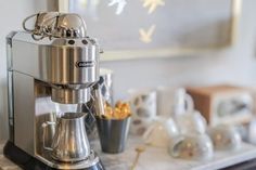 a silver coffee maker sitting on top of a marble counter