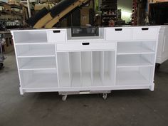 a white cabinet with shelves and drawers in a room filled with other items on wheels