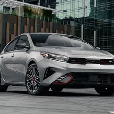 the front end of a silver toyota corolle parked in front of a building