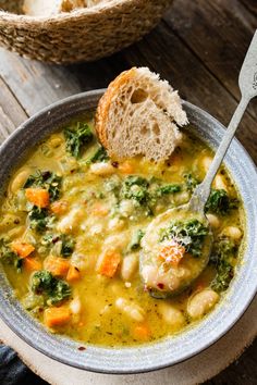 a bowl of soup with chicken, broccoli and carrots