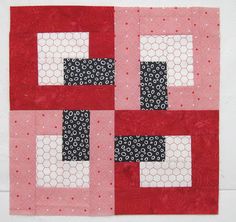 a red and black patchwork quilt with squares on the top, one square has an interlocked pattern