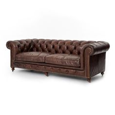 a brown leather couch sitting on top of a white floor