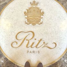 a person standing in front of a sign that says ritz paris