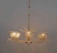 a chandelier with four lights hanging from it's center and three petals on the bottom