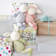 stuffed animals and presents sitting on a table next to each other in front of a white wall