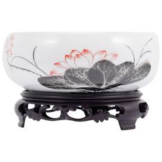 a glass bowl sitting on top of a metal stand with flowers painted on the bottom