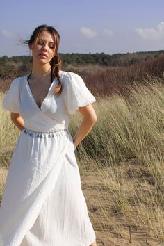 Made from 100% Organic Cotton, the Perla dress is the epitome of romance. With a timeless, bohemian style, this dress features a wrap-around body, short puff sleeves and a relaxed fit that is perfect for any occasion.  Colour: Optic White Size: Model is 6-8 wearing S (sizes come up fairly small)  Fabric: 100% Organic Cotton Elegant V-neck Puff Sleeve Beach Dress, Chic Flowy Wrap Dress With Short Sleeves, Bohemian Flowy Wrap Dress With Surplice Neckline, Bohemian Surplice Neckline Wrap Dress For Brunch, Bohemian Wrap Dress With Surplice Neckline For Brunch, Chic Short Sleeve Wrap Dress For Beach, Elegant Puff Sleeve V-neck Beach Dress, Feminine Surplice Neckline Wrap Dress For Summer, Elegant Short Sleeve Wrap Dress For Beach