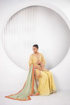 All in the details; this gorgeous festive silhouette is cut from pure cotton net in a refreshing lemon hue is detailed with gota and zardoze work with tiny tassel details on the sleeves and neckline. This short kurta and and dhaka pajama set is paired with a printed silk dupatta with gota and dhanak details. Yellow Mulmul Sharara With Traditional Drape, Yellow Cotton Silk Sharara For Navratri, Yellow Straight Kurta With Sheer Dupatta, Yellow Cotton Silk Kurta With Sheer Dupatta, Yellow Chanderi Kurta With Sheer Dupatta, Festive Pista Green Lawn Suit With Cutdana, Yellow Mulmul Sharara For Wedding, Yellow Cotton Silk Sharara For Wedding, Yellow Cotton Silk Sharara With Dupatta